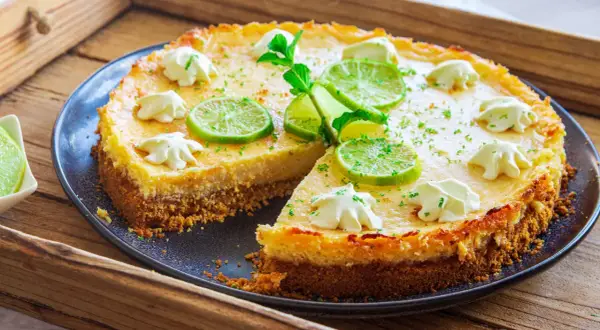 Ein köstlicher Key Lime Pie mit Limettenscheiben und Sahnetupfern, bereit zum Genießen.