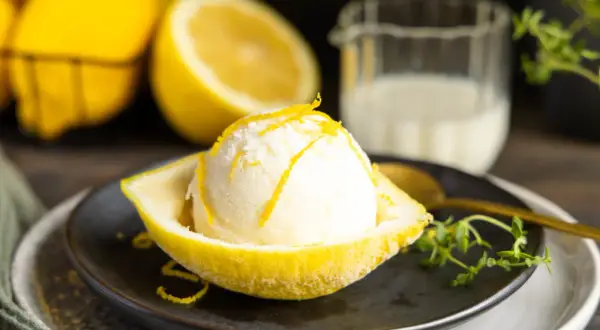 Erfrischendes Buttermilch Zitrone Eis, serviert in einer ausgehöhlten Zitrone, garniert mit Zitronenschale.