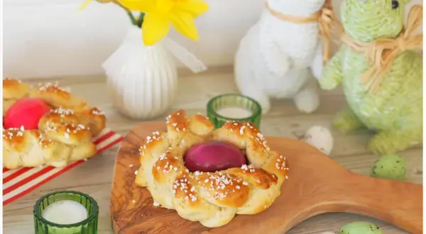 Zwei geflochtene Osterkränze mit gefärbten Eiern, bereit zum Osterfrühstück. Das Backen von Osterkränzen ist eine schöne Tradition.