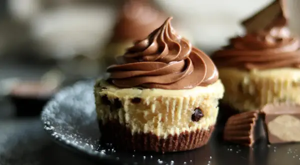 Schokoladen-Cheesecake-Muffins mit zarter Füllung und cremigem Topping, garniert mit Schokostückchen.