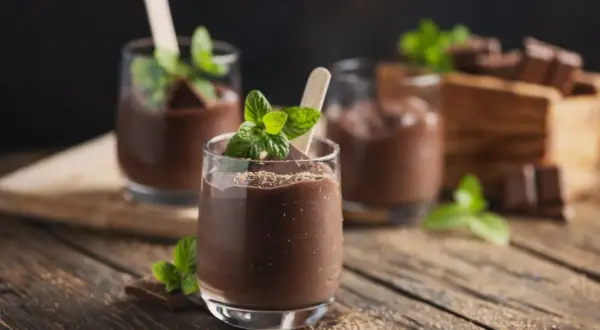 Schokoladenmousse im Glas, garniert mit Minze und Schokostückchen. Perfekt für die Zubereitung mit dem Thermomix.