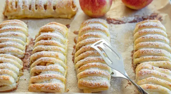 Frisch gebackene Apfeltaschen, bestäubt mit Puderzucker. Ein köstliches Apfeltaschen Rezept zum Nachbacken.