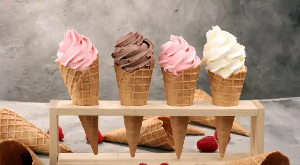 Vier leckere Softeis-Sorten in Waffeln: Erdbeer, Schoko und Vanille. Perfekt, um Softeis selber machen zu lernen und den Sommer zu genießen.