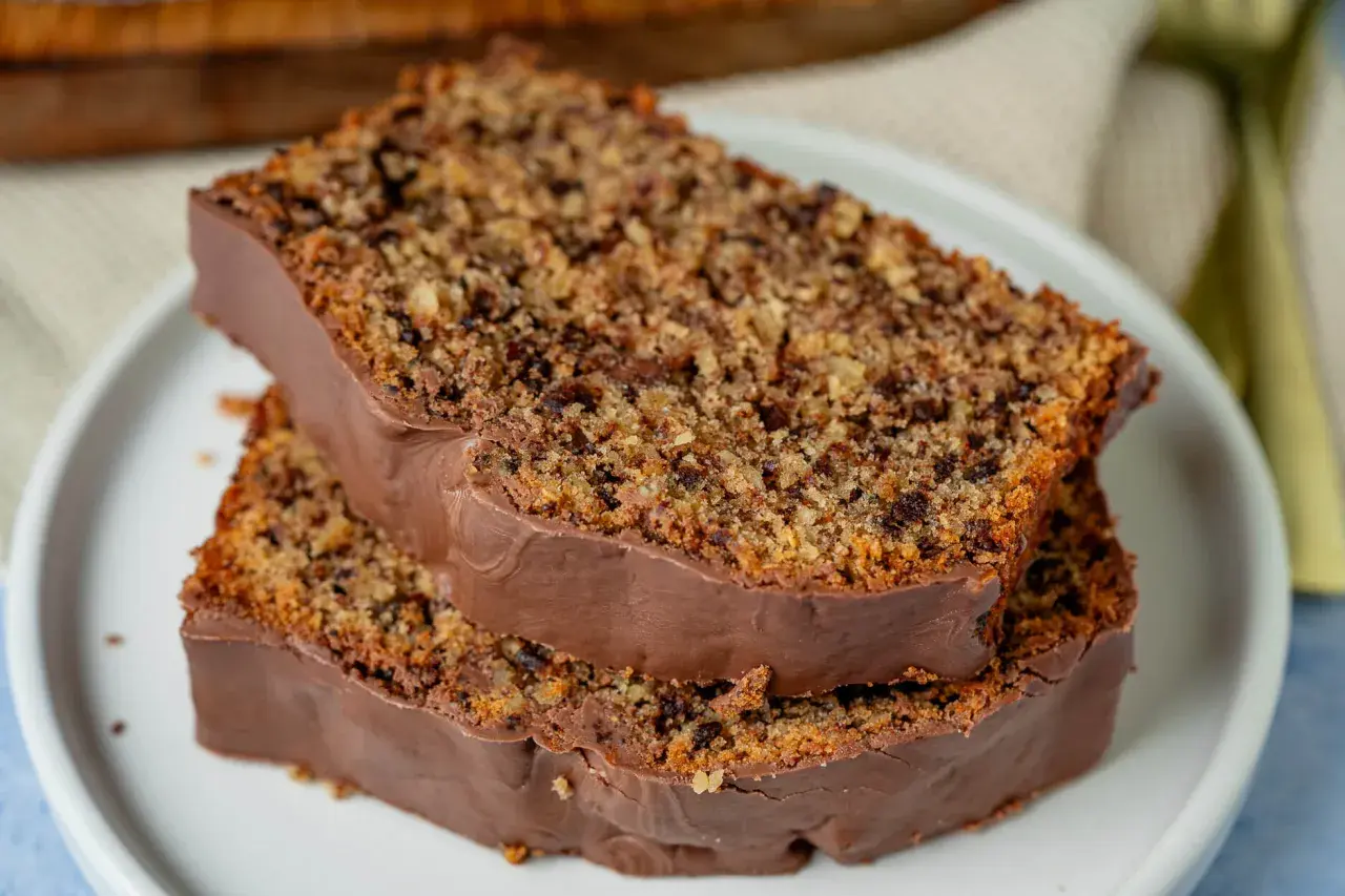 Zwei Scheiben saftiger **Schoko Nuss Kuchen** mit Schokoladenglasur auf einem Teller.