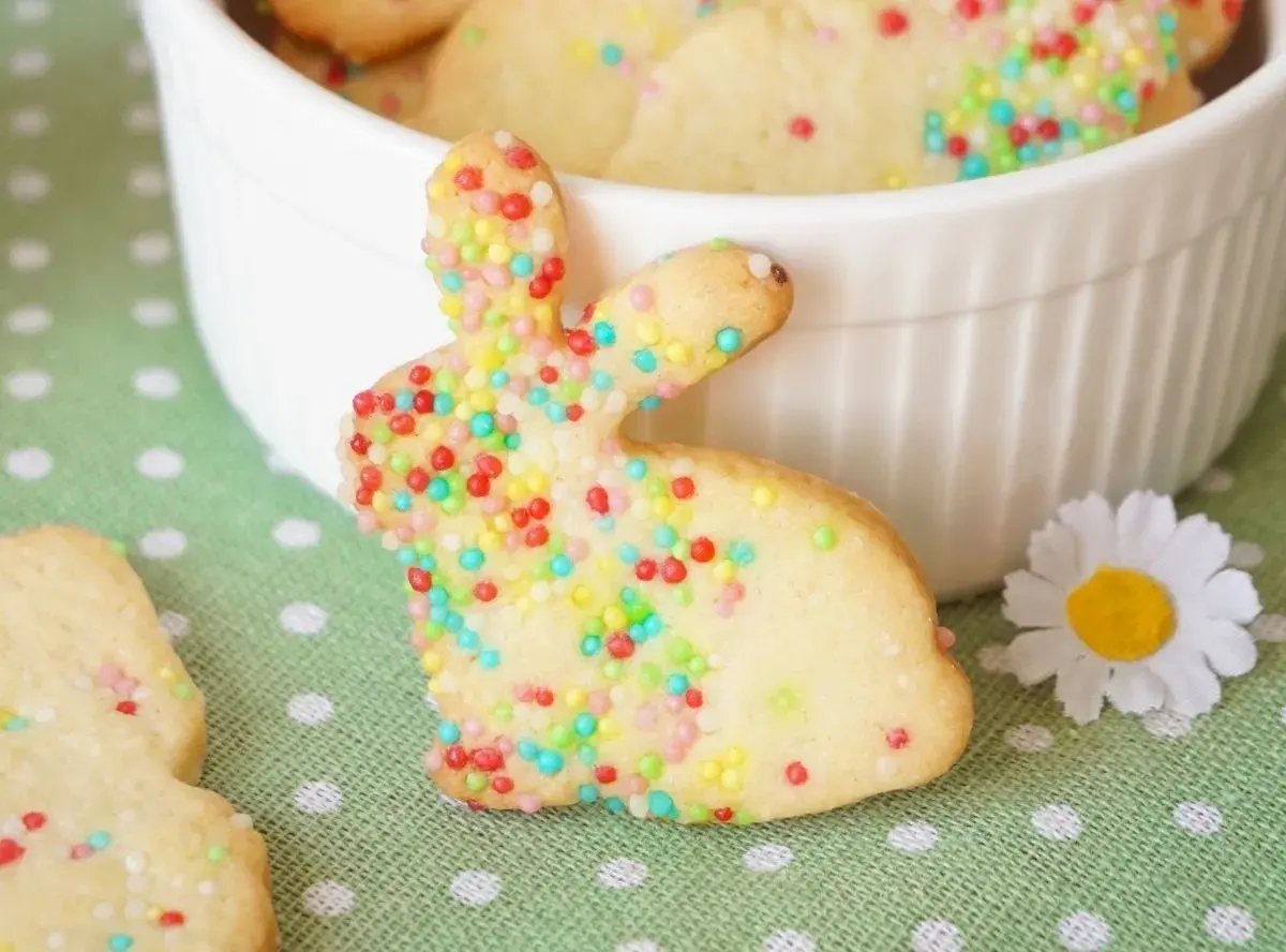 Bunte Osterkekse zum Ausstechen in Hasenform, verziert mit Zuckerstreuseln. Ein süßer Gruß für das Osterfest.
