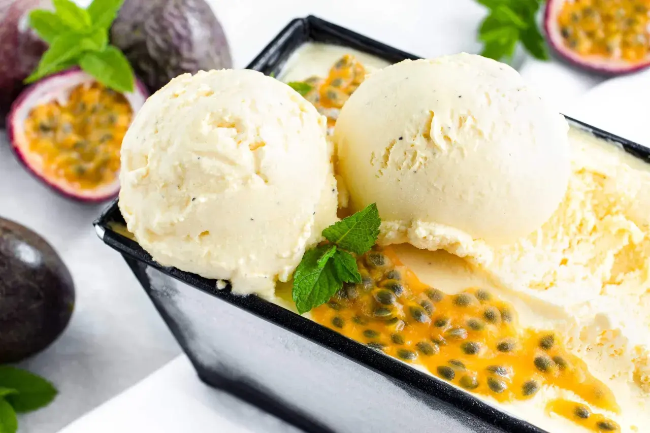 Zwei Kugeln cremiges Maracuja Eis mit frischer Passionsfrucht und Minze. Ein tropischer Genuss!