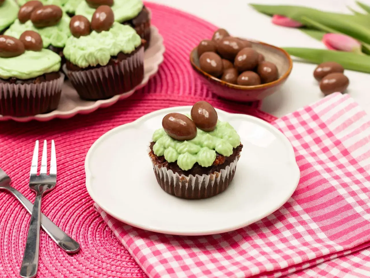 Schokoladen-Oster-Cupcakes mit hellgrüner Glasur und Schokoladen-Eiern, bereit zum Genießen.