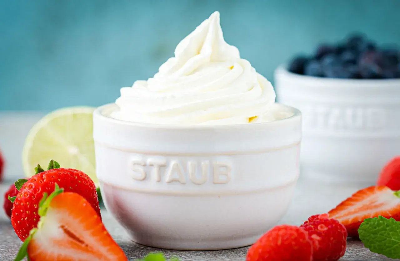 Cremiger Frozen Joghurt, frisch aus der Eismaschine, umgeben von saftigen Erdbeeren und Blaubeeren.