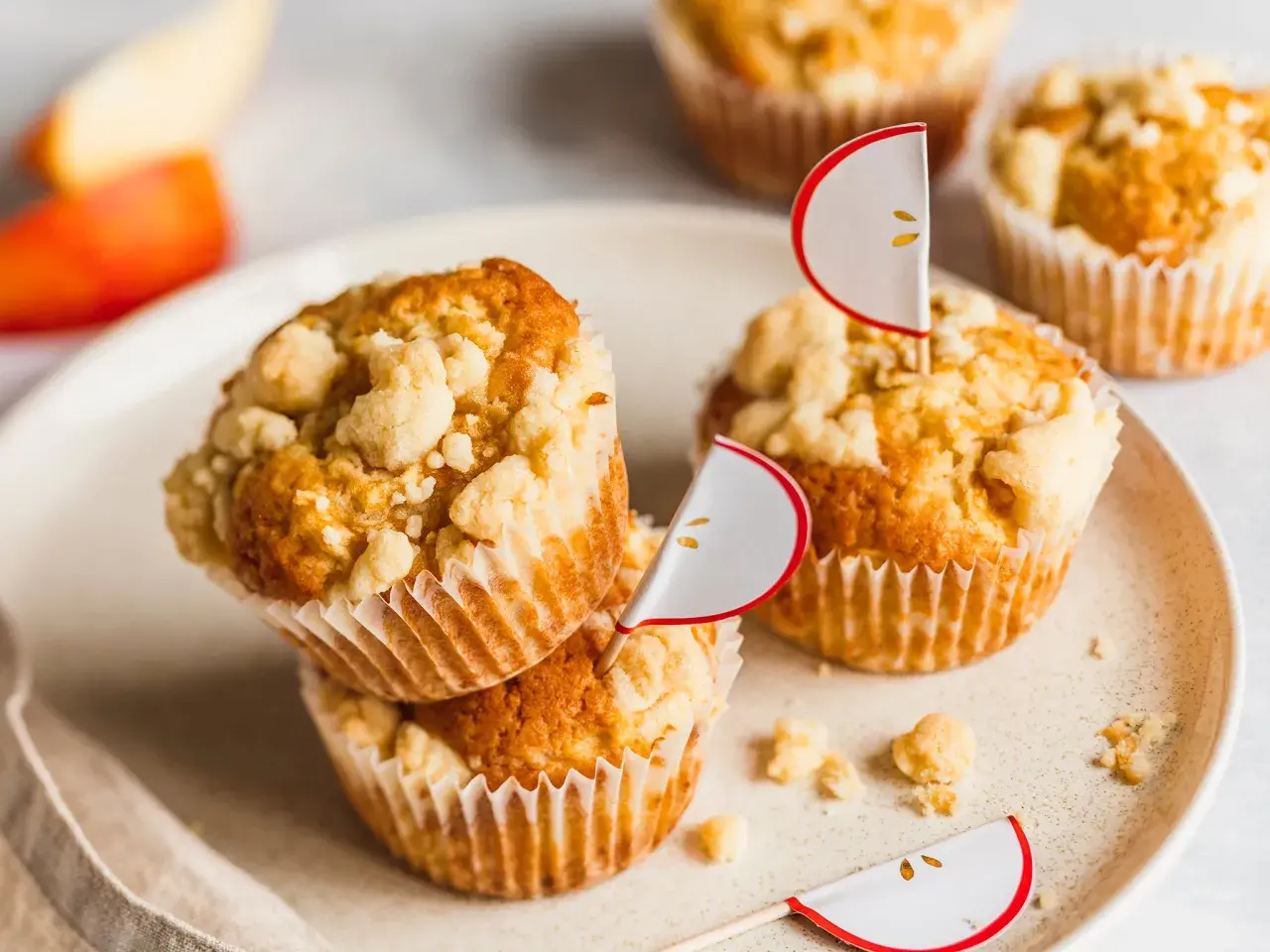 Saftige Apfel Streusel Muffins mit süßer Kruste, dekoriert mit kleinen Apfel-Fähnchen. Ein Genuss für jeden Anlass.