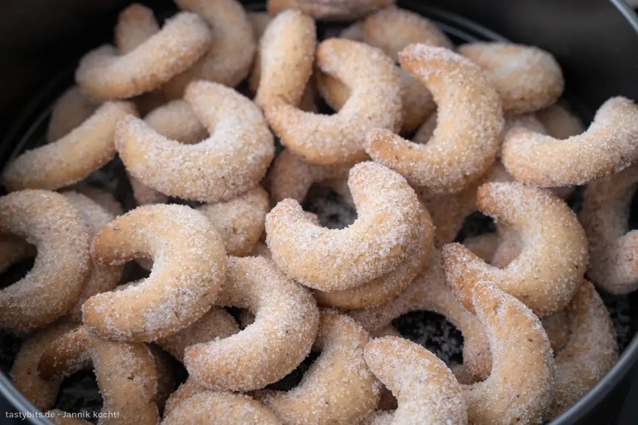 Ein Haufen zarter Vanillekipferl, bestreut mit feinem Zucker, wartet darauf, genossen zu werden.