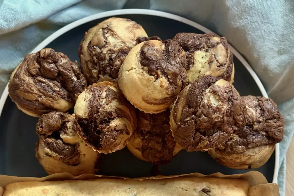 Ein Haufen leckerer Nutella Muffins mit Marmormuster auf einem Teller, bereit zum Genießen.