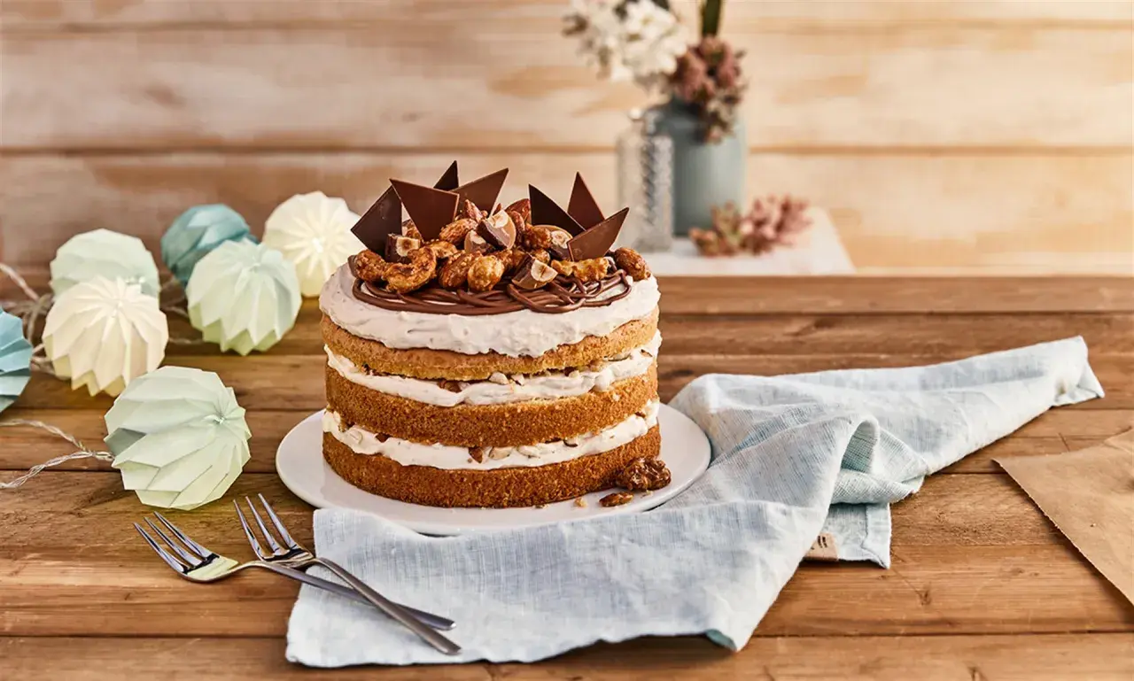 Eine köstliche Nougat Torte mit Schokoladenstücken und Nüssen, dekoriert mit einer Kordel aus Papierlaternen.