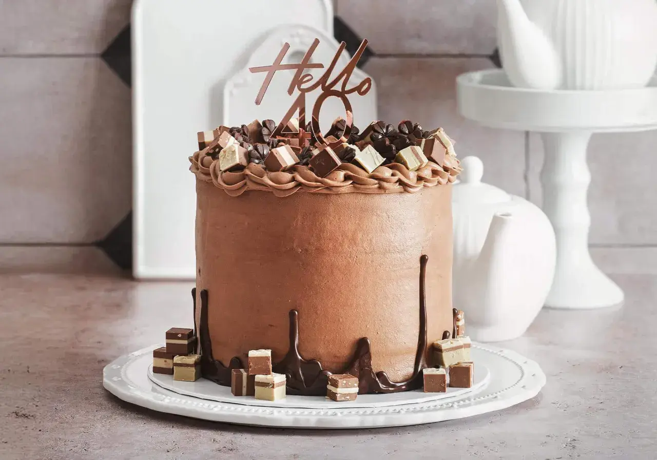 Eine üppige Schoko Torte mit "Hello 40" Topper und Schokoladenstückchen.