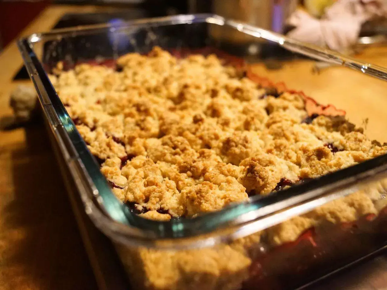 Frisch gebackener Himbeer Crumble in einer Glasform. Die goldbraune Kruste duftet verlockend nach Beeren und Streuseln.