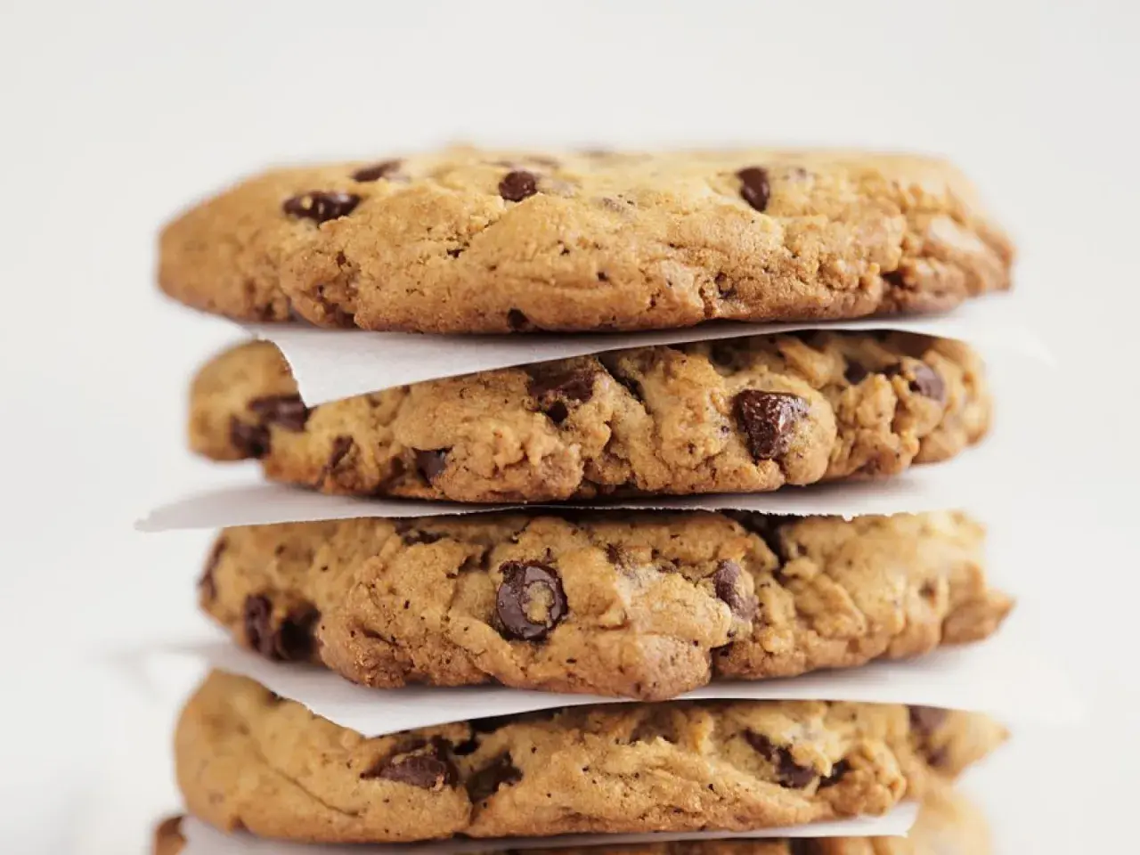 Stapel von vier saftigen Chocolate Chip Cookies, perfekt für Ihr nächstes Rezept.