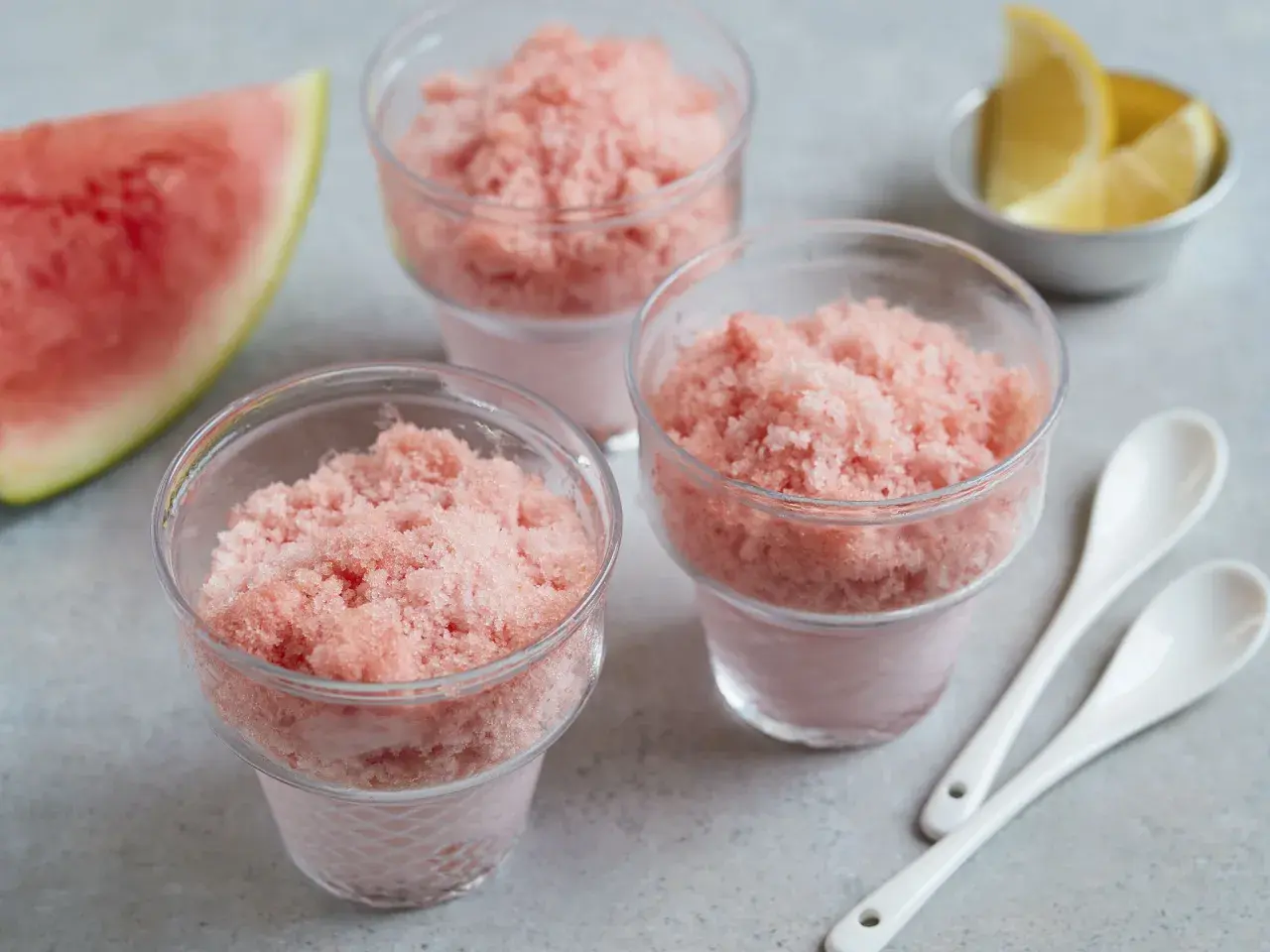 Erfrischendes Wassermelonen-Shave-Ice-Rezept in Gläsern, garniert mit Zitronenspalten und Wassermelone. Perfekt für heiße Tage!