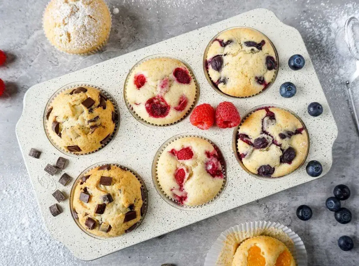 Saftige Muffins mit Schokolade, Himbeeren und Blaubeeren im Muffinblech. Ein köstliches Muffins Rezept für jeden Anlass.