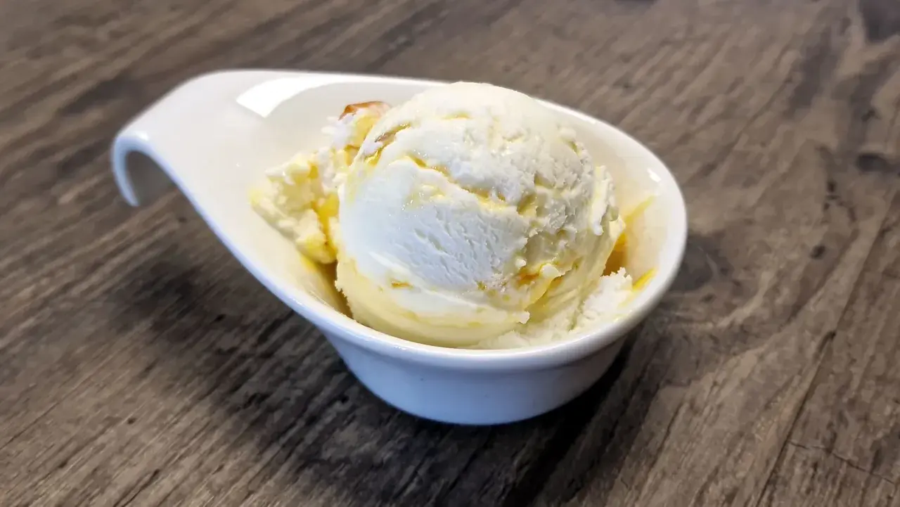 Cremiges Vanilleeis mit Honig-Swirls in einer weißen Schale. Perfekt, wenn du Lust hast, eispulver selber machen.