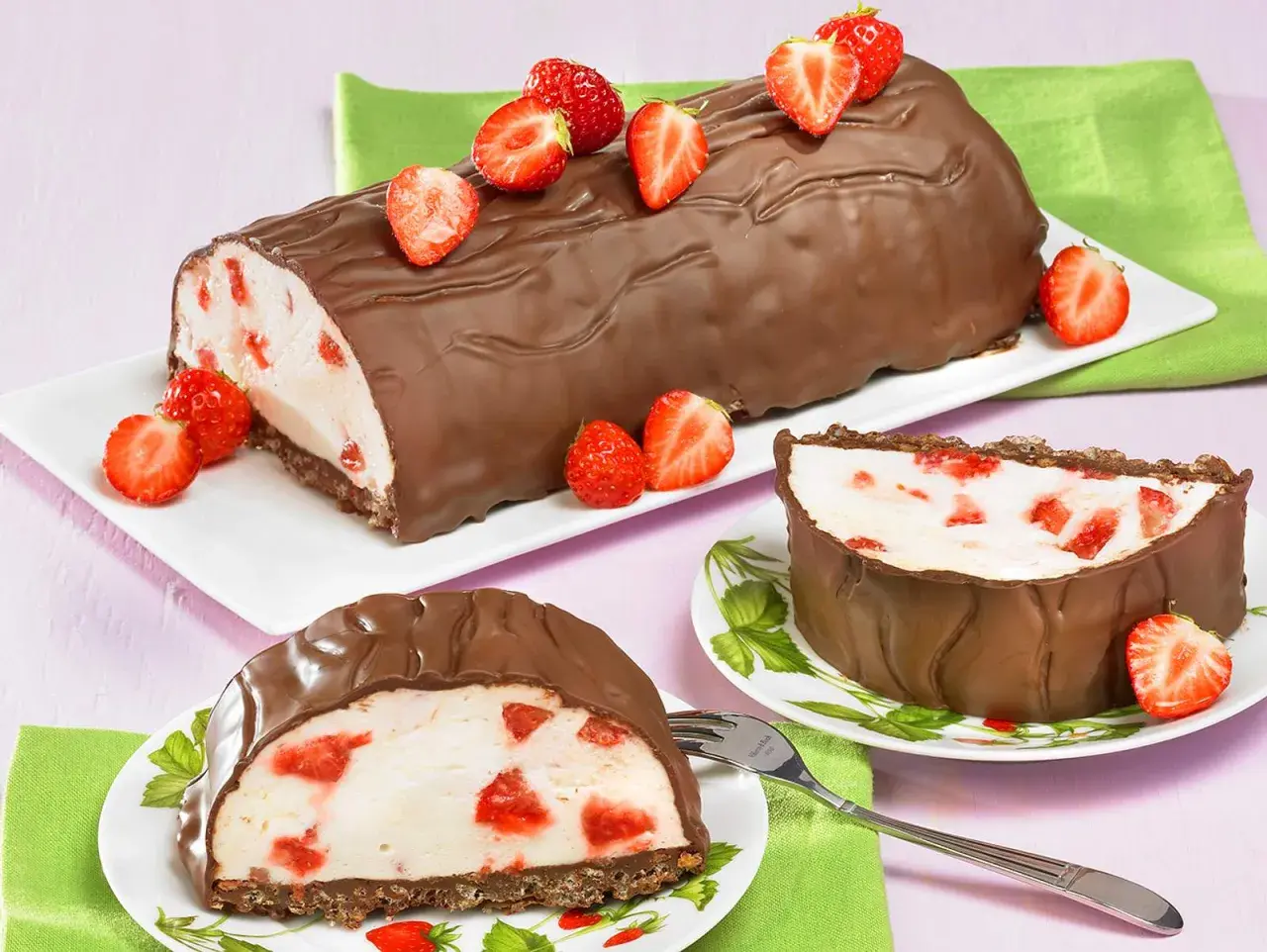 Schokoladenrolle mit Joghurt-Erdbeer-Füllung, garniert mit frischen Erdbeeren. Eine köstliche Joghurette Torte für den Sommer.
