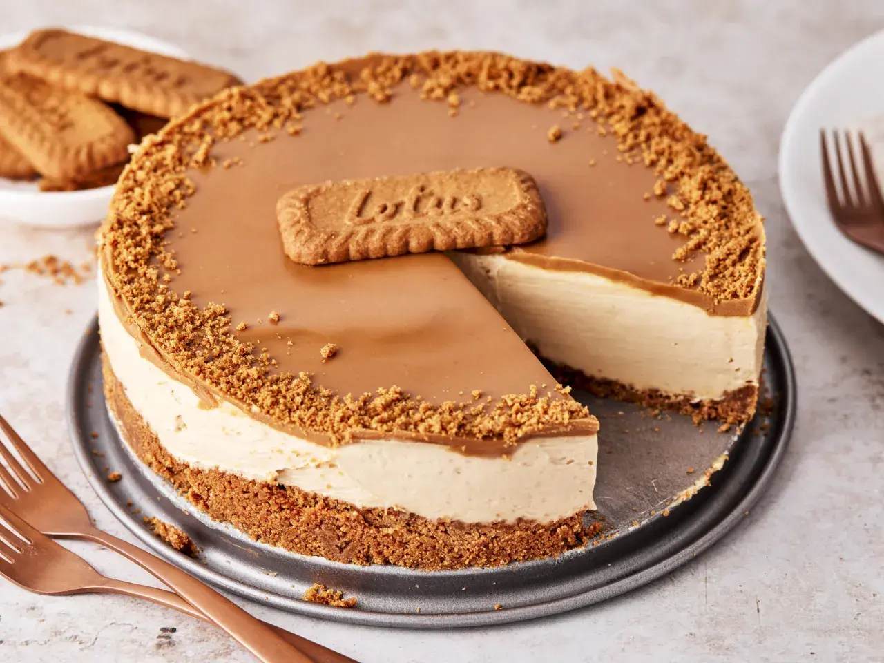 Ein köstlicher Biscoff Cheesecake mit Karamellglasur und Keksbröseln, dekoriert mit einem Lotus-Keks.