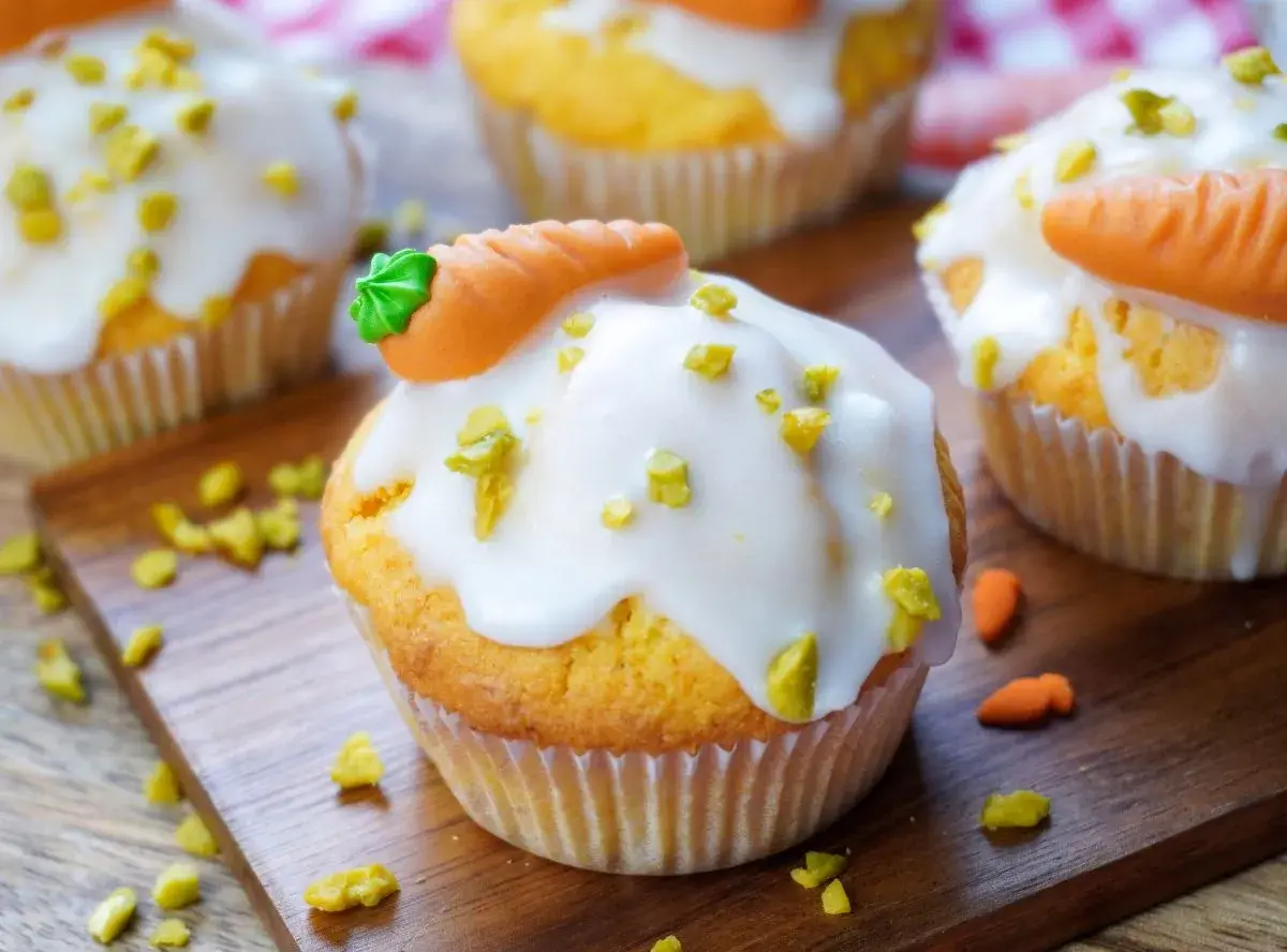 Leckere, schnelle Muffins mit weißer Glasur und kleinen Marzipan-Karotten. Perfekt für den Osterbrunch!