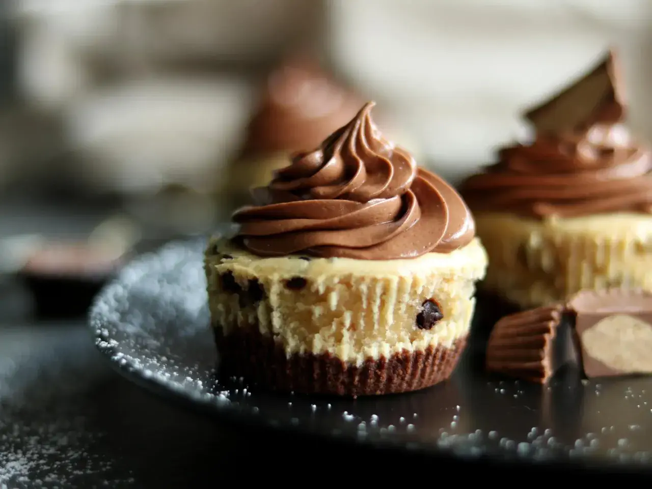 Schokoladen-Cheesecake-Muffins mit zarter Füllung und cremigem Topping, garniert mit Schokostückchen.