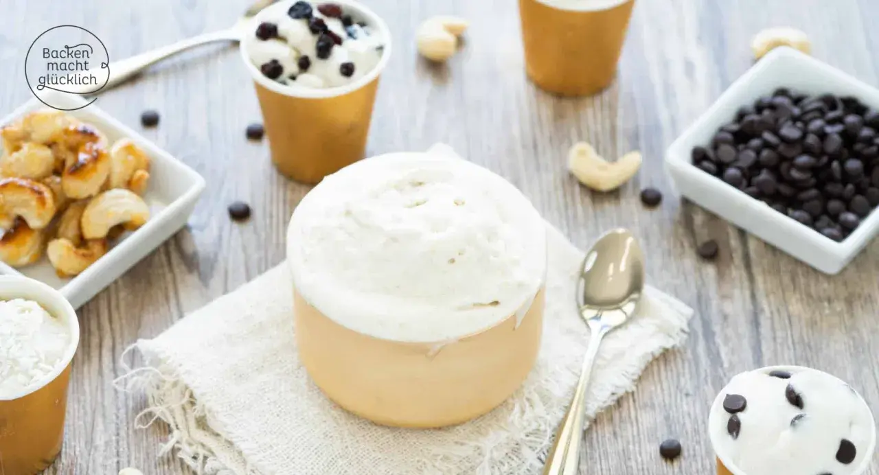 Cremiges Vanilleeis ohne Ei, serviert in Bechern, mit Cashews und Schokodrops daneben.