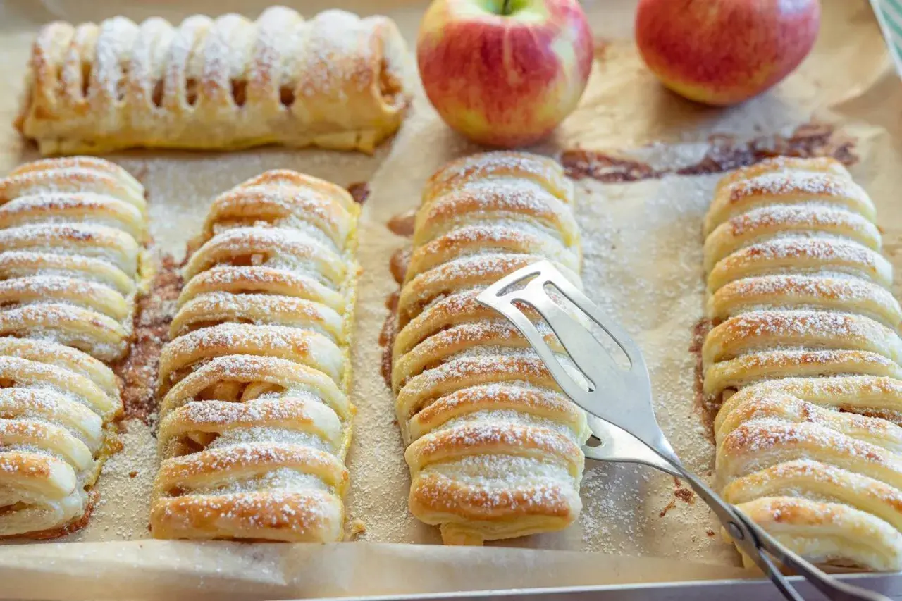 Frisch gebackene Apfeltaschen, bestäubt mit Puderzucker. Ein köstliches Apfeltaschen Rezept zum Nachbacken.