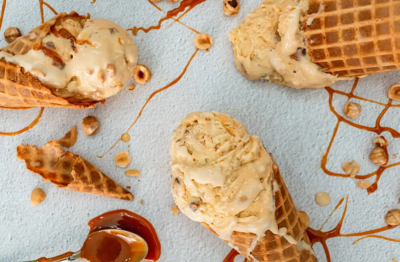 Drei Eiswaffeln mit karamell eis, Nüssen und Karamellsauce.