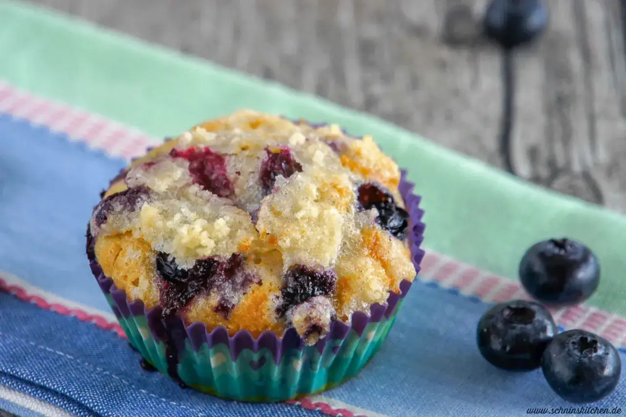 Ein saftiger Blaubeermuffin mit Streuseln, perfekt für ein Blaubeermuffins Rezept. Frische Blaubeeren zieren den Teig.