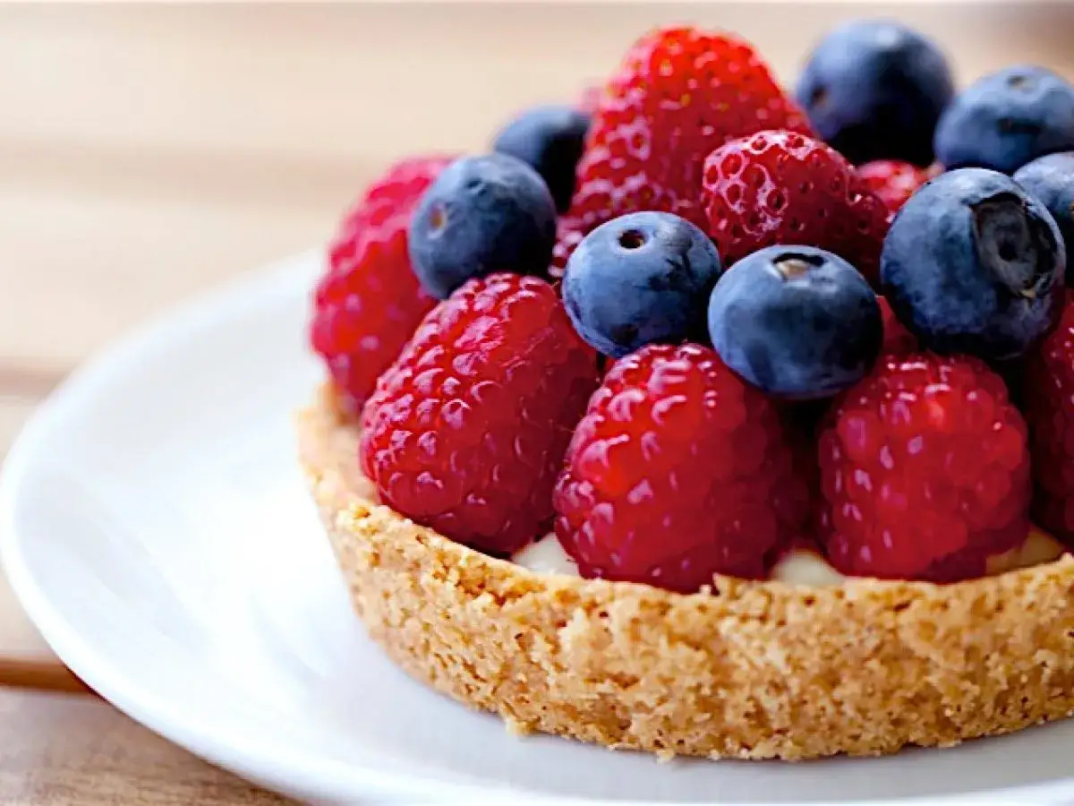 Ein köstliches Tartelettes Rezept mit frischen Himbeeren, Blaubeeren und Erdbeeren auf einem knusprigen Boden.