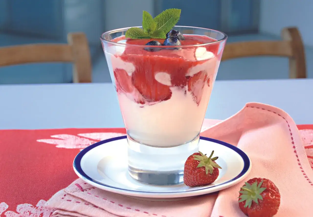 Cremiges Dessert im Glas mit Erdbeeren, Blaubeeren und Minze. Ein Hauch von Zitrone, wie bei einem feinen lemon curd, rundet den Genuss ab.