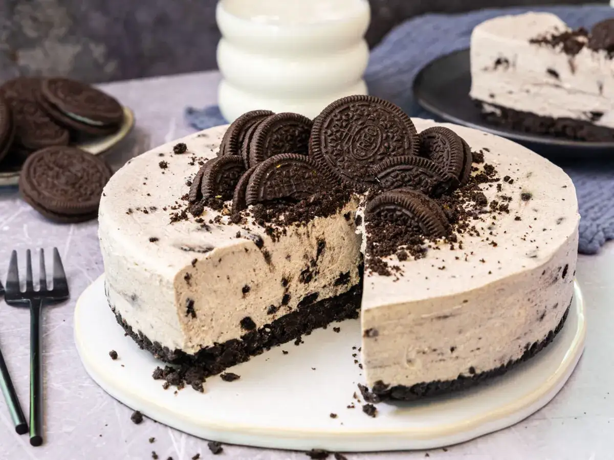 Eine köstliche Oreo Torte, dekoriert mit ganzen und zerbrochenen Keksen, wartet darauf, angeschnitten zu werden.