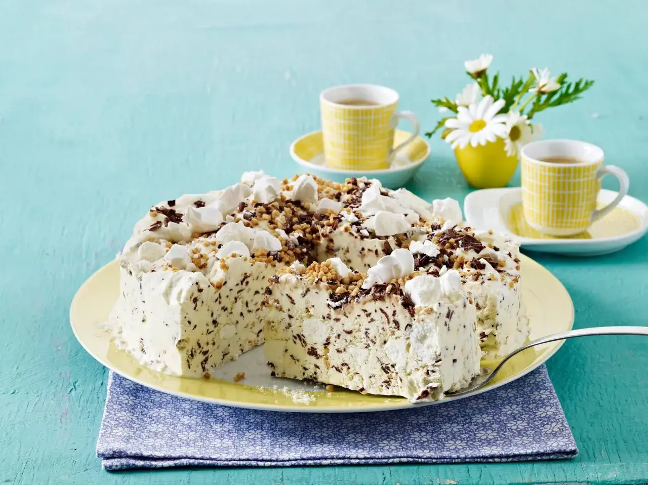 Omas eistorte, eine köstliche Mischung aus Eis, Schokolade und Nüssen, serviert mit zwei Tassen Kaffee und einem Blumenstrauß.