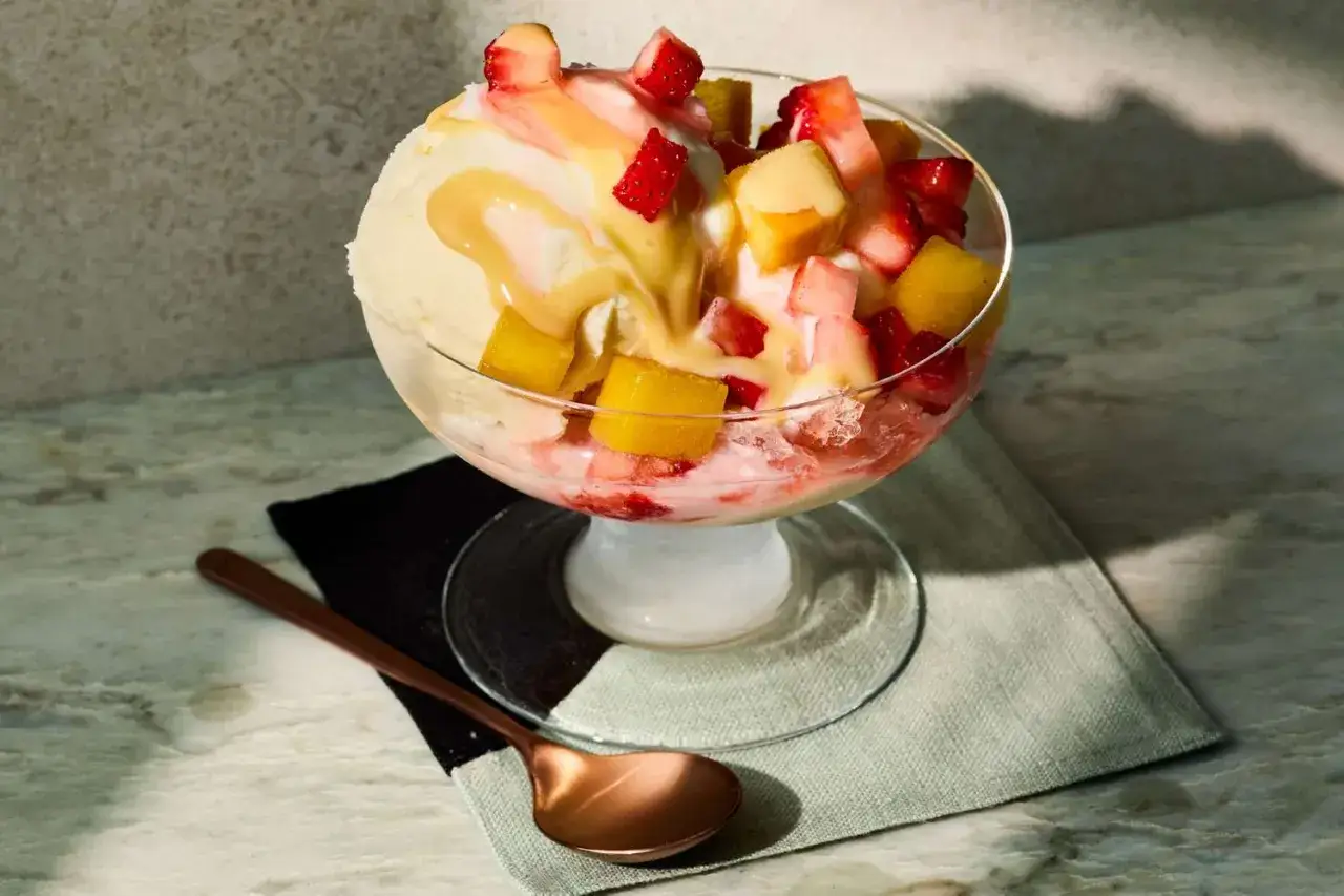Ein erfrischendes Dessert mit Vanilleeis, zerstoßenem Eis, Erdbeeren und Mango. Perfekt für ein einfaches shave ice rezept.