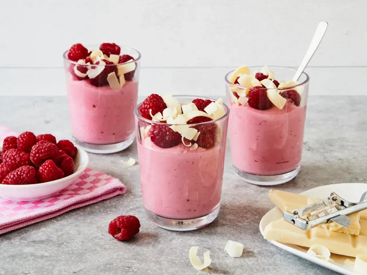 Himbeermousse mit wei&szlig;er Schokolade, zubereitet im Thermomix, garniert mit frischen Himbeeren und Schokosp&auml;nen.