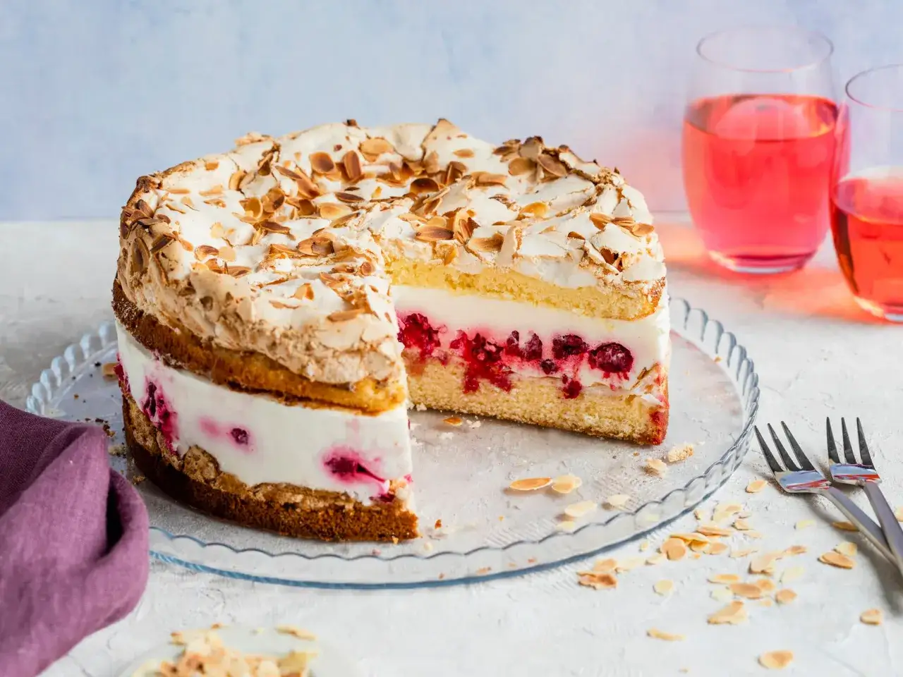 Himmlische Torte mit Baiserhaube und Mandelsplittern, gefüllt mit Sahne und roten Beeren. Ein Genuss für die Sinne!
