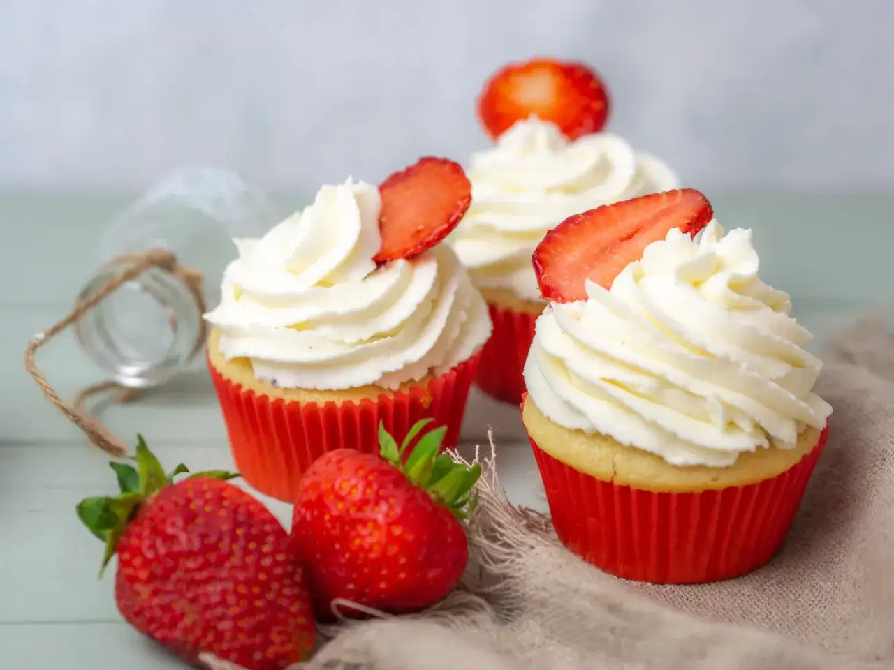 Saftige Erdbeeren krönen Cupcakes mit luftiger Erdbeer-Buttercreme. Ein süßer Genuss!