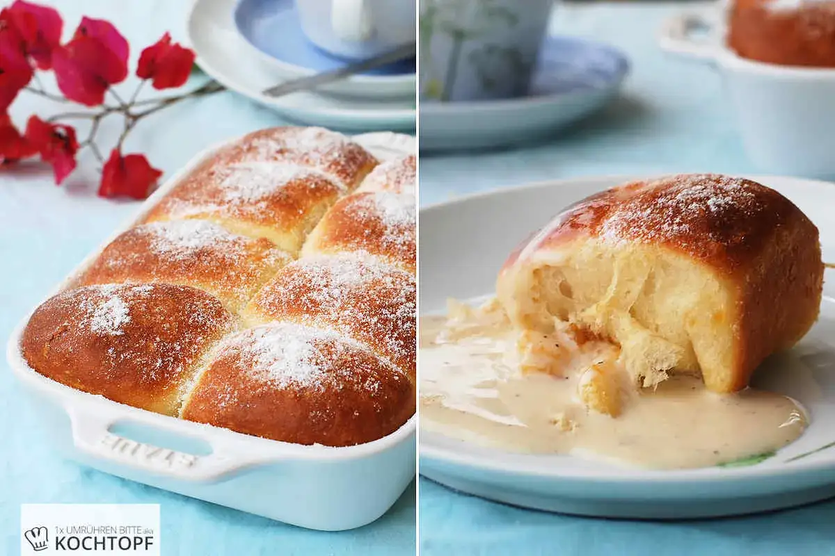 Goldbraune Buchteln, frisch aus dem Ofen, mit Puderzucker best&auml;ubt. Ein Buchtel wird aufgeschnitten und zeigt die weiche F&uuml;llung, umgeben von Vanillesauce. Ein k&ouml;stliches Buchteln Rezept!