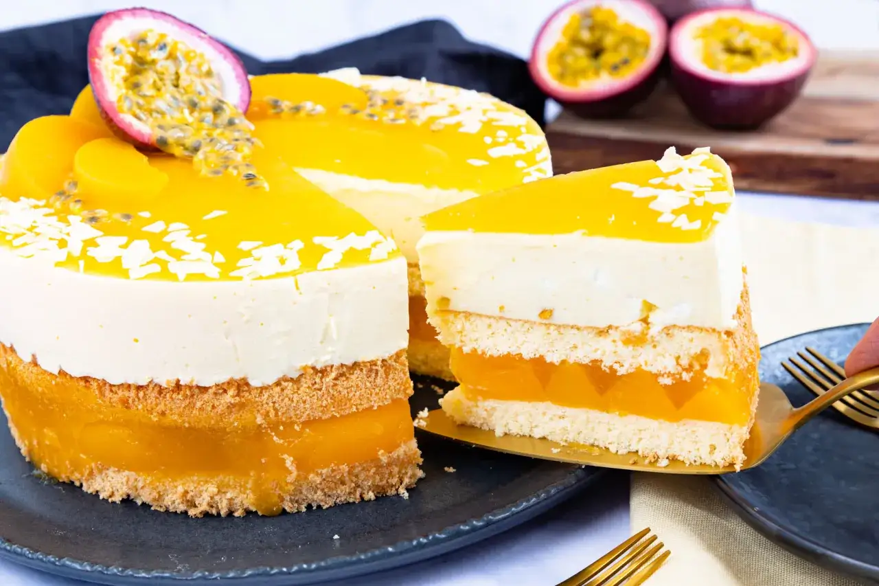 Eine köstliche Pfirsich Maracuja Torte mit fruchtiger Füllung und cremigem Topping, garniert mit frischen Früchten und Kokosraspeln.