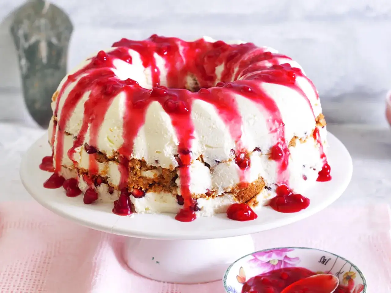 Ein k&ouml;stlicher Gugelhupf mit cremiger F&uuml;llung und roter Fruchtsauce, perfekt f&uuml;r ein besonderes Dessert.