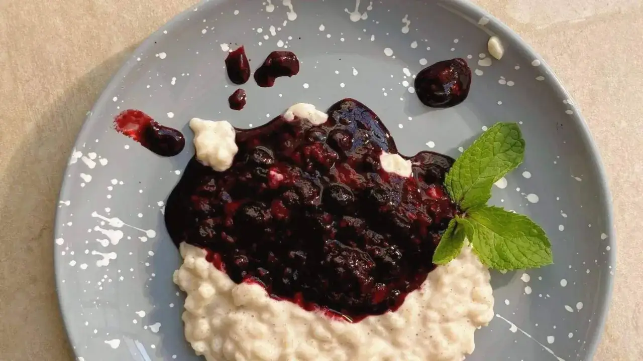 Cremiger Milchreis mit dunkler Beerensoße und Minze, ein köstliches Milchreis Rezept für Genießer.