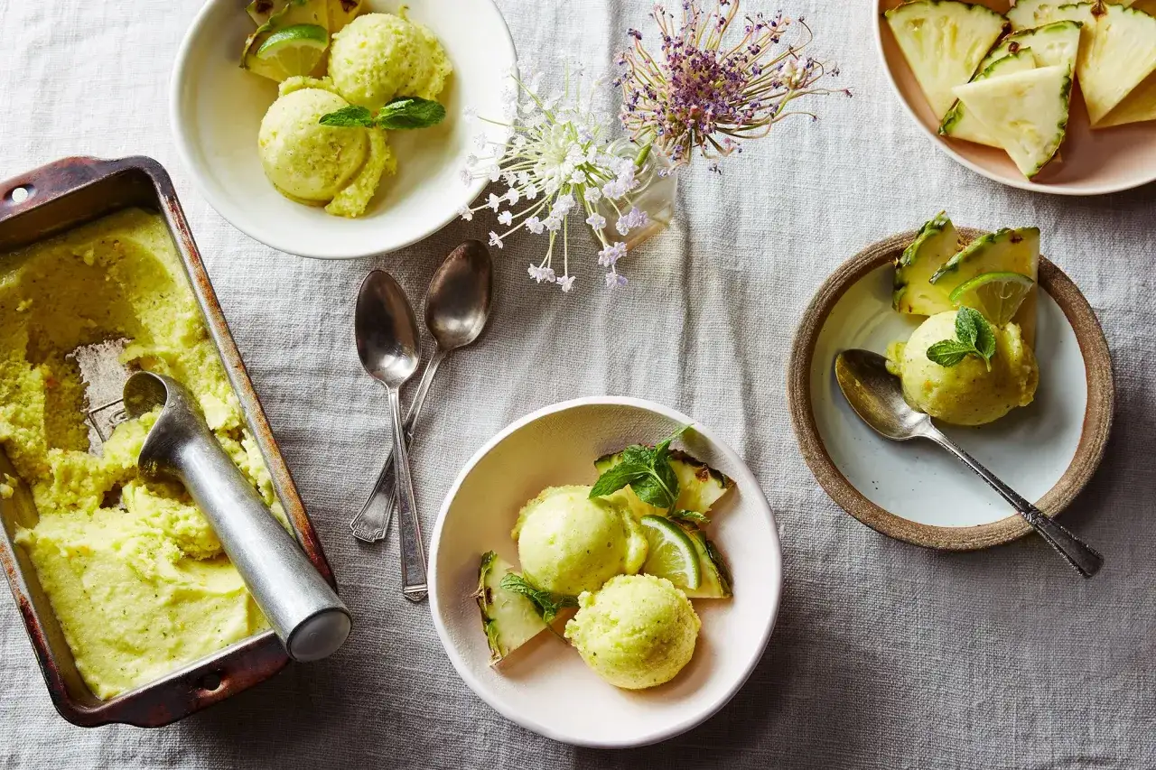 Erfrischendes Ananas-Limetten-Sorbet, perfekt zum sorbet selber machen ohne eismaschine. Serviert mit frischen Ananasstücken und Minze.