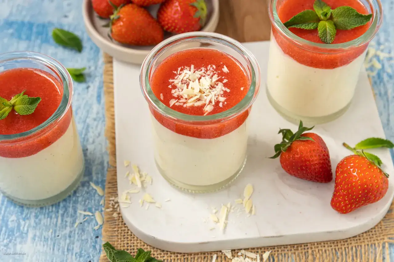 Panna Cotta mit Erdbeersoße, einfach im Thermomix zubereitet. Mit frischen Erdbeeren und Minze garniert.