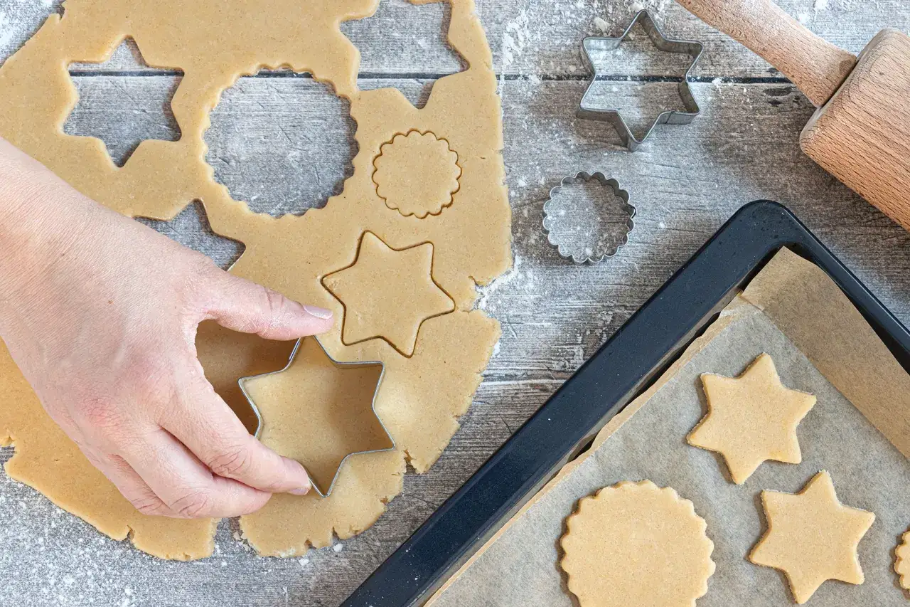 Hand formt Sterne aus Teig mit Ausstechern. Das perfekte ausstecher rezept für Weihnachtsgebäck.