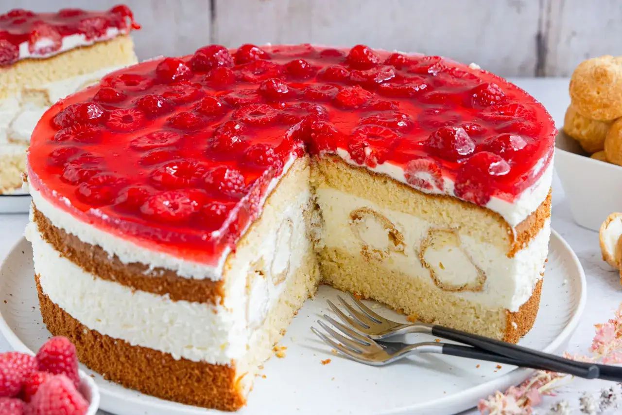 Eine k&ouml;stliche Windbeuteltorte mit Himbeeren und Sahne, bereit zum Genie&szlig;en.