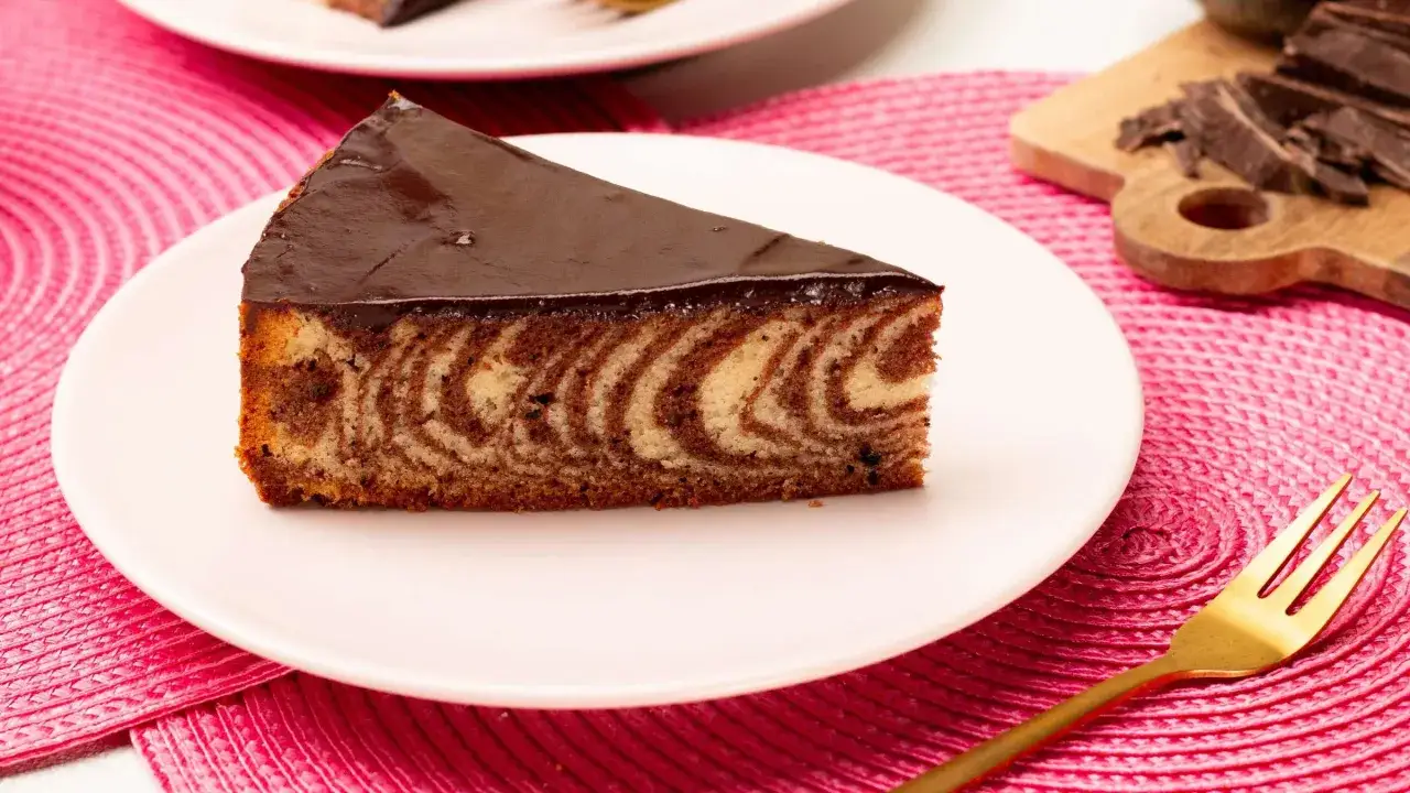 Ein Stück saftiger Zebrakuchen mit Schokoladenglasur, perfekt für Ihr nächstes Zebrakuchen Rezept.