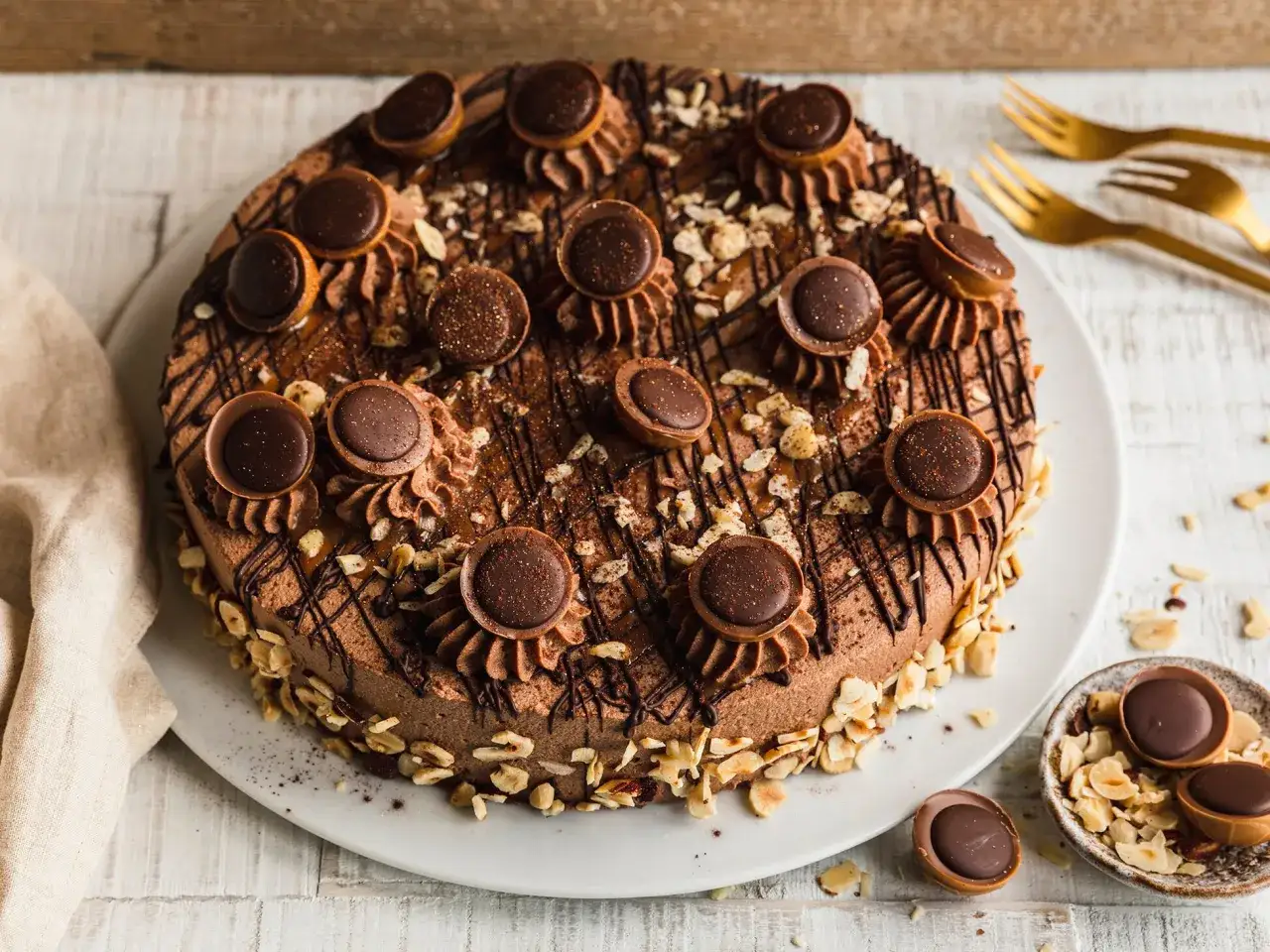 Eine k&ouml;stliche Schokoladen-Toffifee-Torte, verziert mit Toffifee-Pralinen, Schokostreuseln und gehackten N&uuml;ssen.