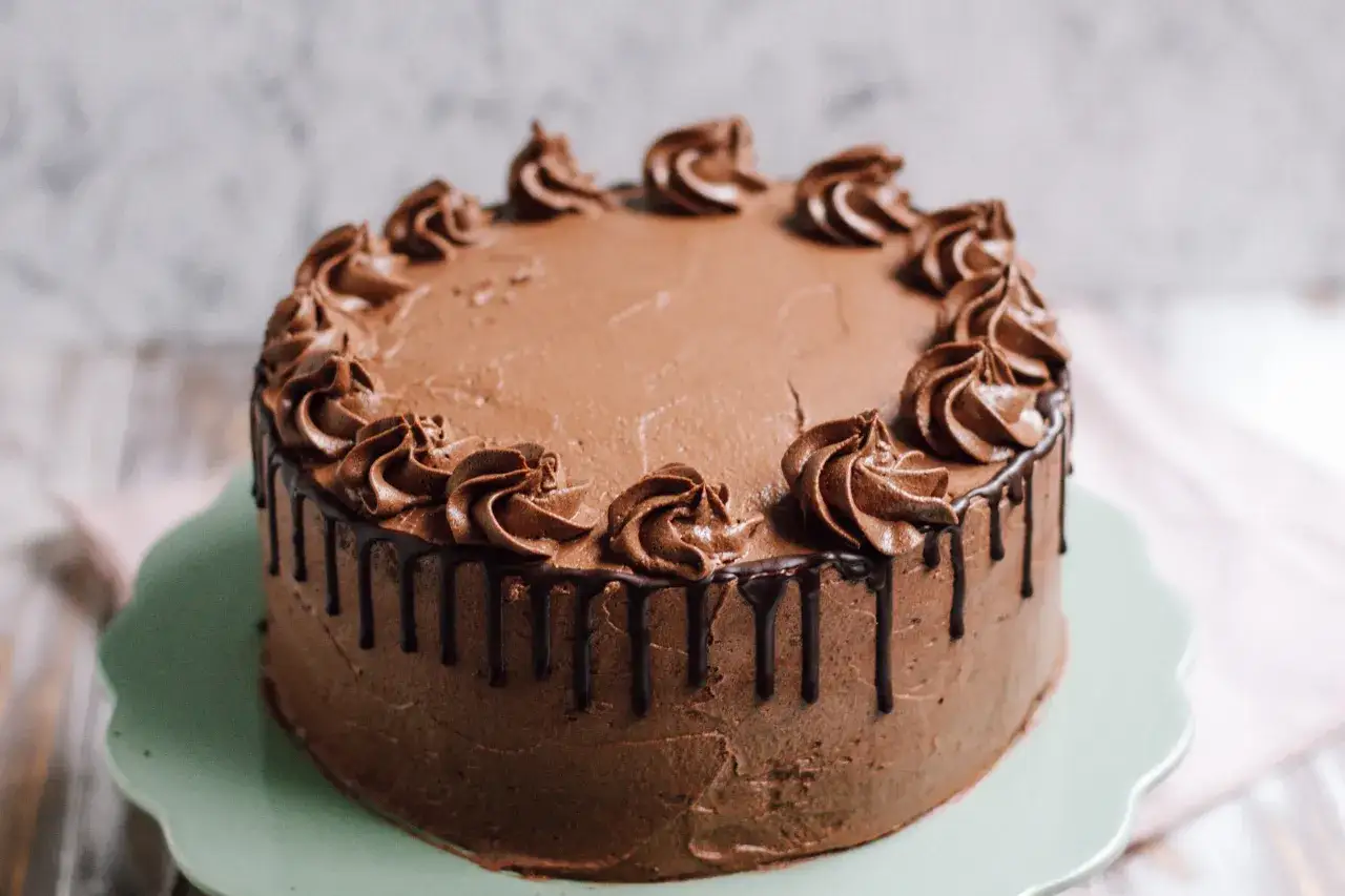 Eine köstliche Schokocreme Torte mit Schokoladenglasur und Sahnetuffs, bereit zum Genießen.