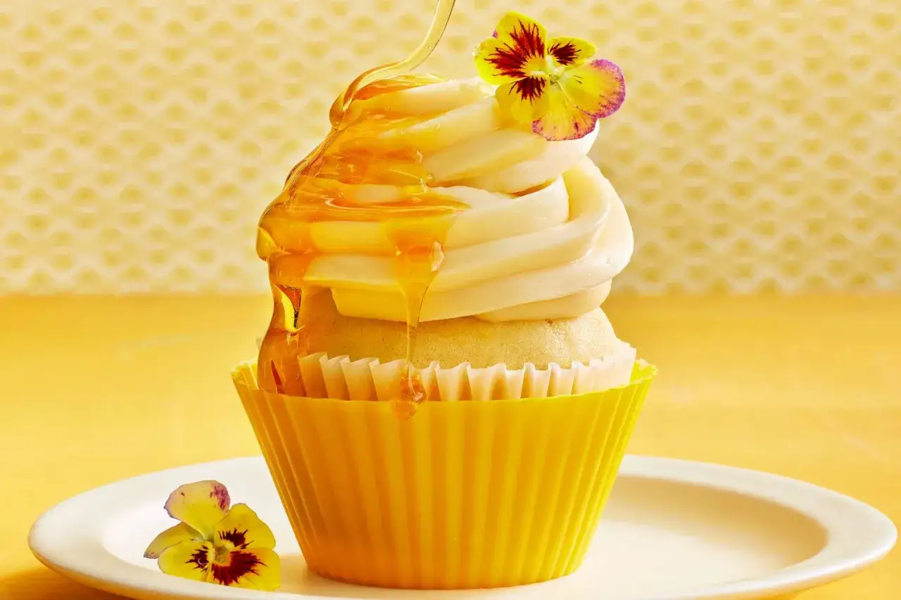 Ein köstlicher Cupcake mit Honig-Topping, garniert mit einer essbaren Blume. Perfekt für ein einfaches Cupcake Rezept.